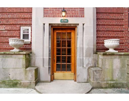 Entrance of a brick building with a wooden door and decorative stone elements.