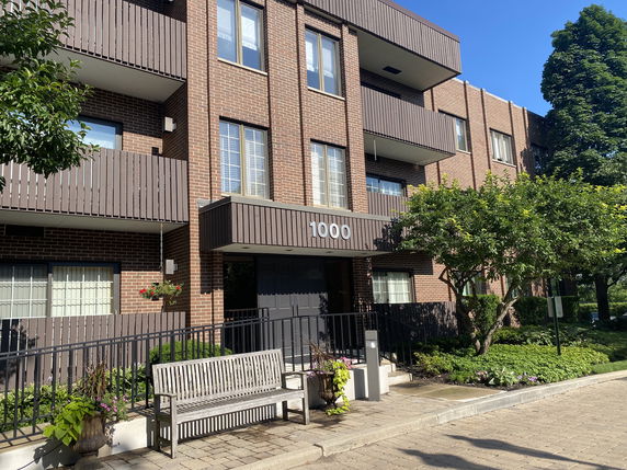 Front view of a multi-story brick apartment building with balconies.