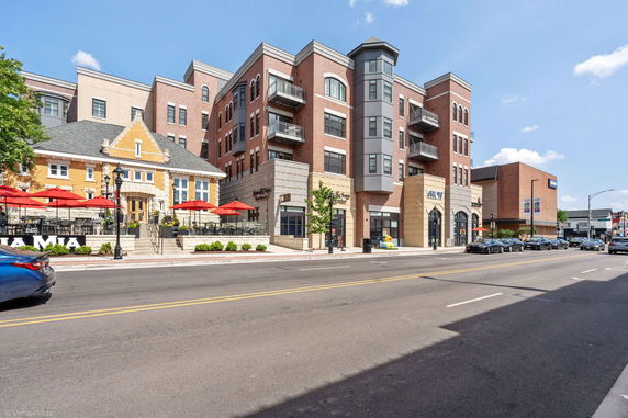 Front view of a multi-story mixed-use building with brick and stone façade.
