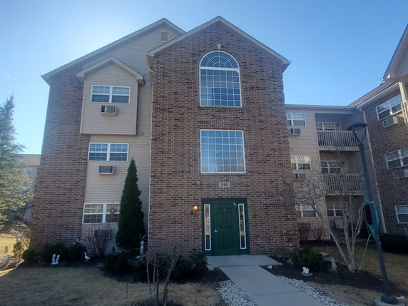 Front view of a multi-story building with brick exterior and large windows.
