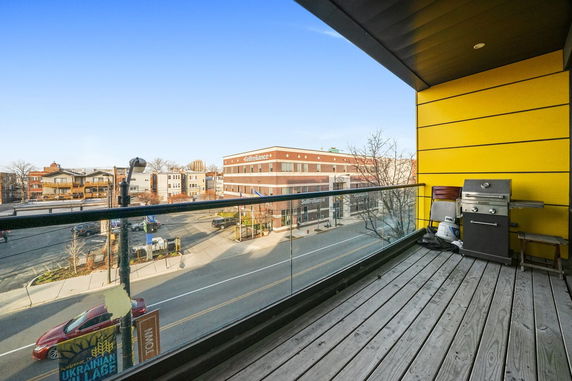 Panoramic view from a balcony with a glass railing and a grill.