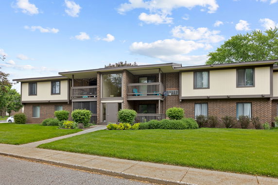 Front view of a two-story apartment building with brick and panel exterior.