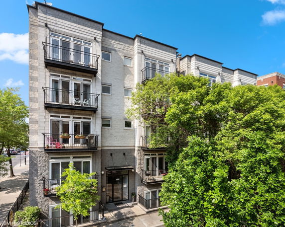 Front view of a multi-story building with balconies.