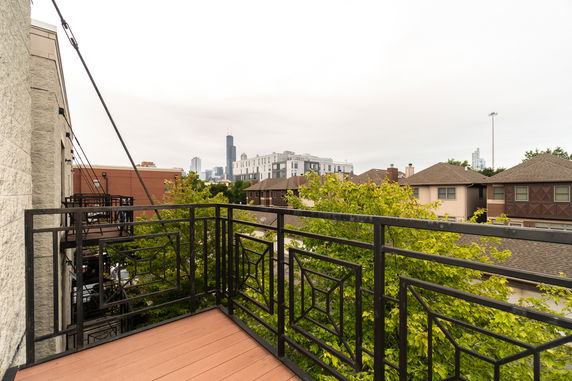 View from a balcony showing residential and urban surroundings with buildings in the distance.
