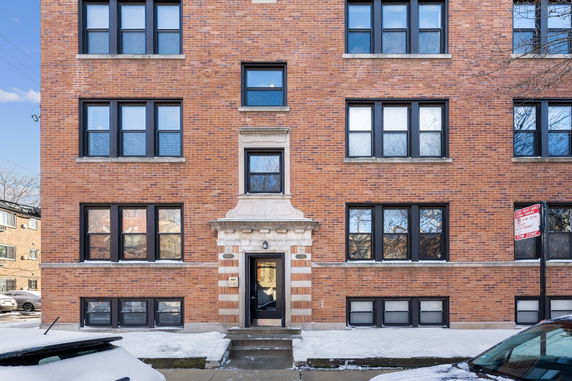 Front view of a multi-story brick building with multiple windows.
