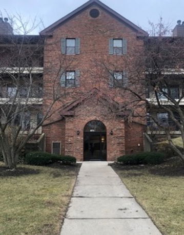 Front view of a multi-story brick building with a central entrance.