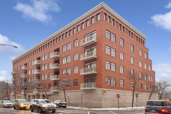 Front view of a multi-story brick building with balconies.