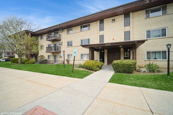 Front view of a three-story apartment building with balconies.