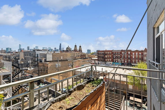 Panoramic view of urban buildings and city skyline from a balcony.