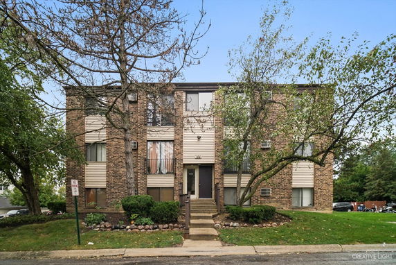 Front view of a brick apartment building with multiple windows.