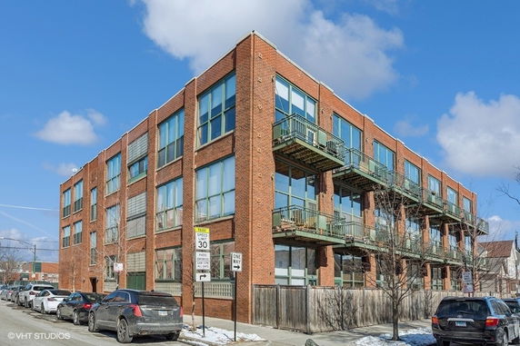 Front view of a multi-story brick building with balconies.