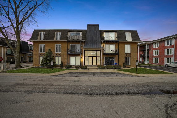 Front view of a multi-story residential building with balconies.