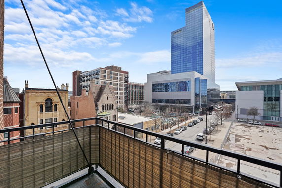 Panoramic view from a balcony overlooking urban buildings and a street.