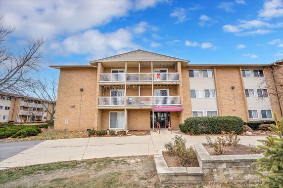 Front view of a three-story residential building with balconies.