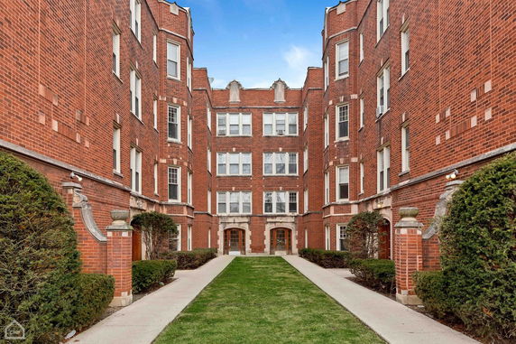 Front view of a multi-story brick building with multiple entrances.