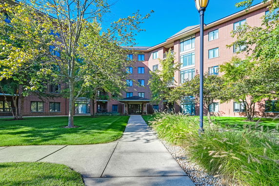 Front view of a multi-story brick building with a walkway leading to the entrance.