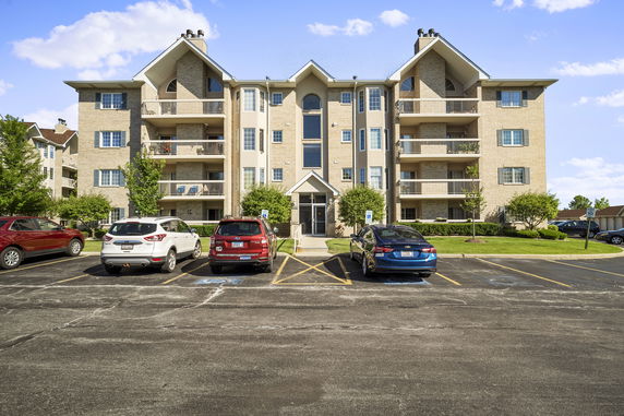 Front view of a multi-story apartment building with balconies.