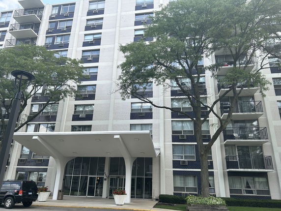 Front view of a multi-story apartment building with balconies.