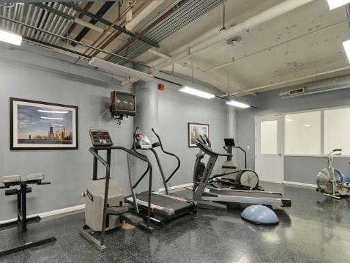 An indoor gym area with exercise equipment including treadmills, an elliptical machine, and weights.