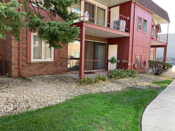Front view of a multi-story building with brick and red paneling.