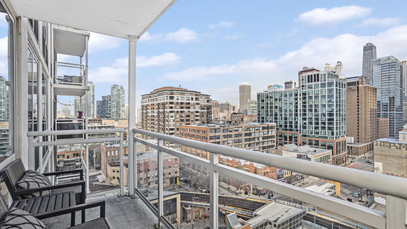 Panoramic view of city buildings from a balcony.