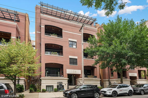 Front view of a multi-story brick apartment building with several balconies.
