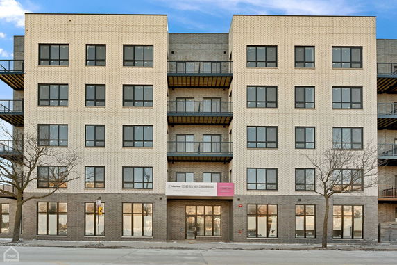 Front view of a multi-story building with balconies and large windows.