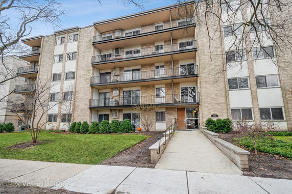 Front view of a multi-story apartment building with balconies.