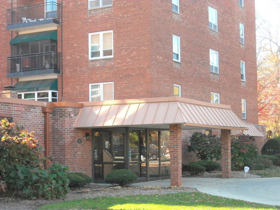 Front view of a multi-story brick building with a covered entrance.