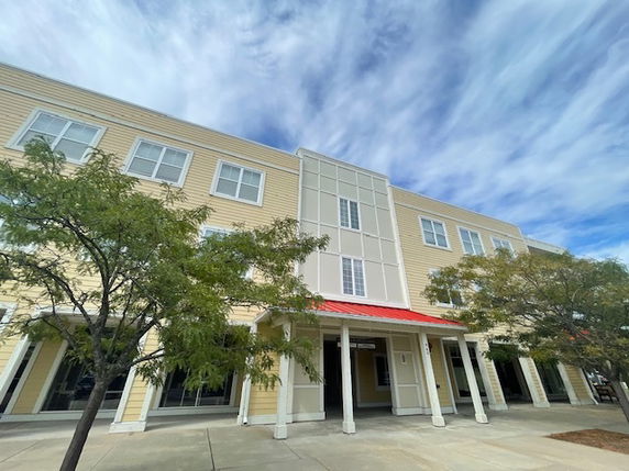 Front view of a multi-story building with a red roof entrance.
