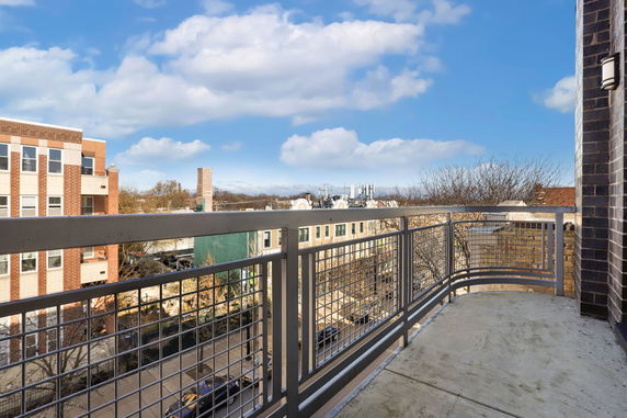 Balcony view overlooking urban buildings and cityscape.