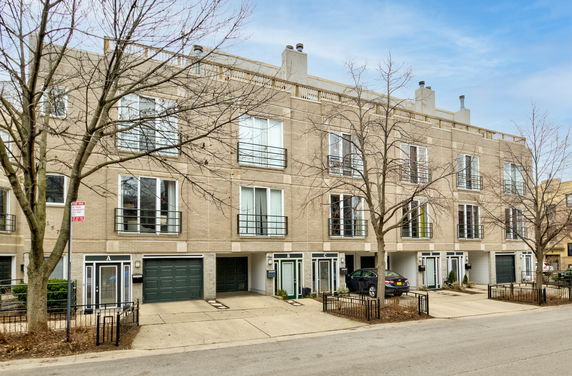 Front view of a multi-story residential building with garages.