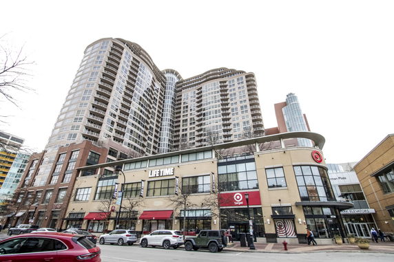 Front view of a multi-story commercial and residential building with shops at the ground level.