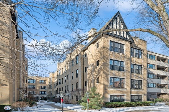 Front view of a multi-story residential building with large windows and distinctive architectural features.