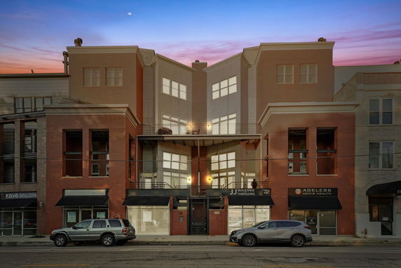 Front view of a modern multi-story commercial building with large windows and balconies.