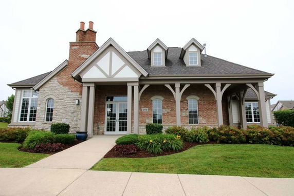 Front view of a house with multiple dormer windows and a large chimney.