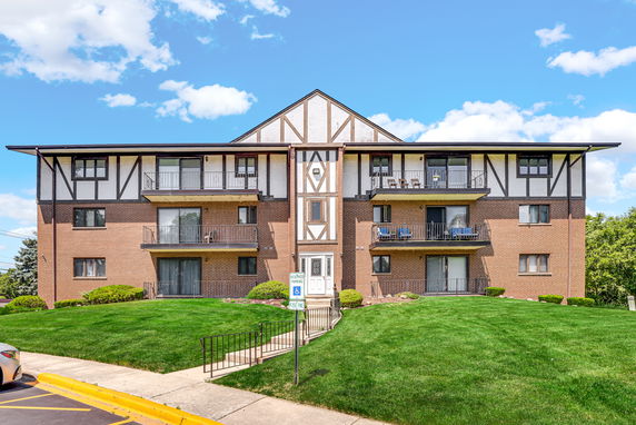 Front view of a three-story apartment building with balconies.