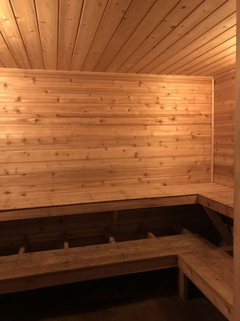Wood-paneled sauna room with benches.