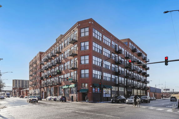 Front view of a multi-story brick building with balconies on each floor.