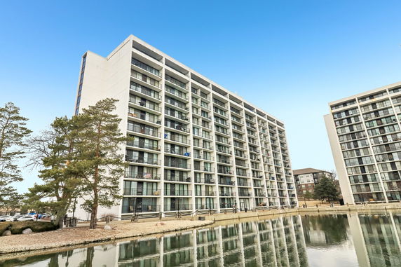 View of a multi-story apartment building with balconies and glass windows.
