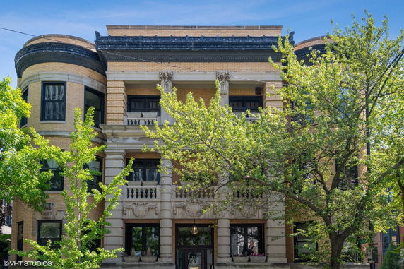 Front view of a historic multi-story building with ornate columns and decorative masonry.