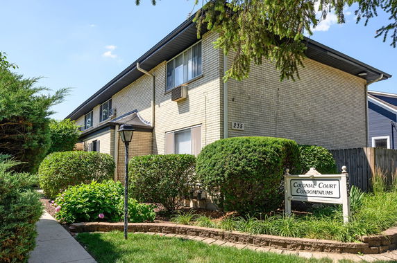Front view of a two-story condominium building with brick exterior.