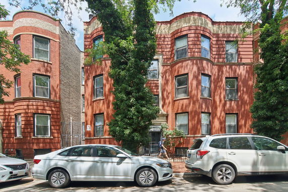 Front view of a brick apartment building with bay windows.