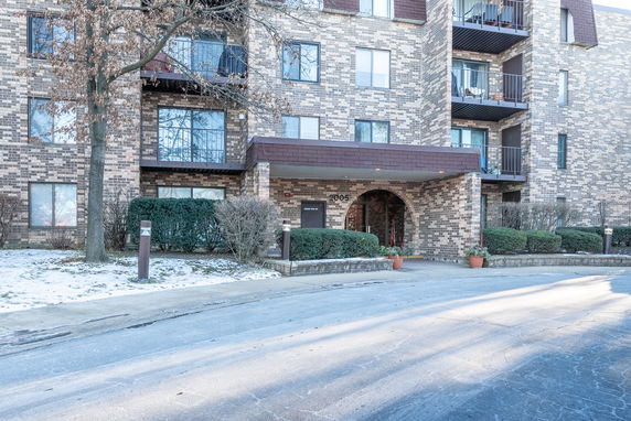 Front view of a multi-story residential building with brick facade and balconies.