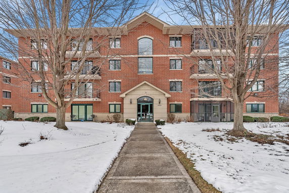 Front view of a multi-story brick building with several balconies.