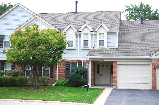 Front view of a two-story house with a garage and a gabled roof.