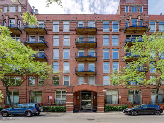 Front view of a multi-story brick building with balconies.