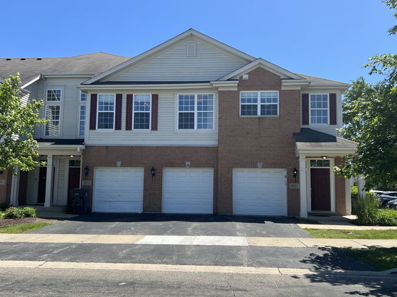 Front view of a two-story house with a double garage and brick facade.