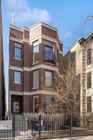 Front view of a three-story brick townhouse.