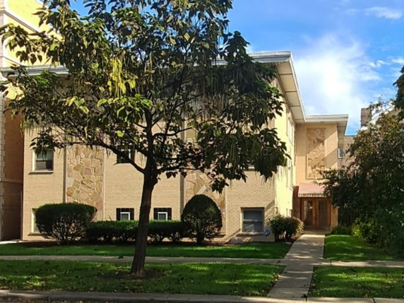 Front view of a multi-story house with a brick exterior and small entrance awning.